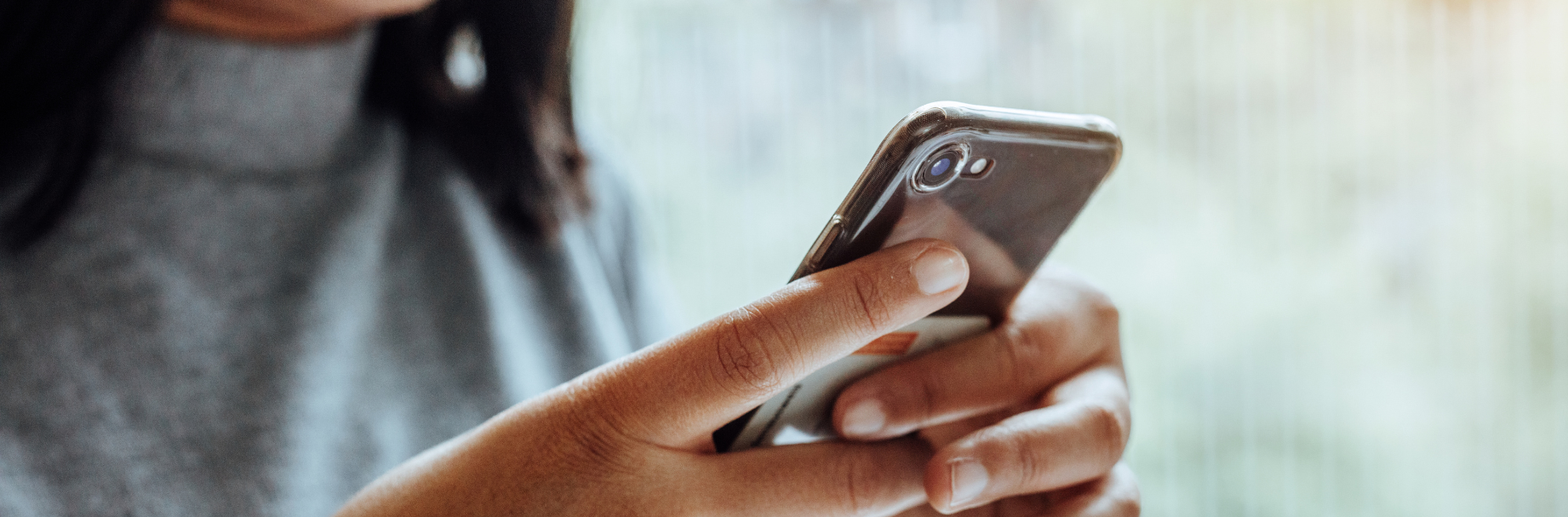 Woman holding a cell phone and looking at it